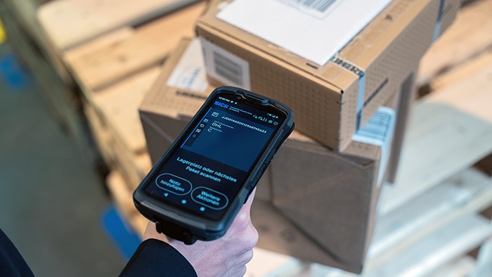 Handheld scanning device used for digital identification of incoming goods on stacked transport packages
