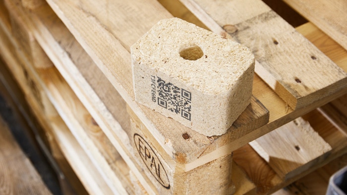 A pallet block with a QR code rests on a stacked wooden EPAL pallet.