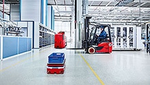 An AGC, AGV and a forklift move about in a production hall.